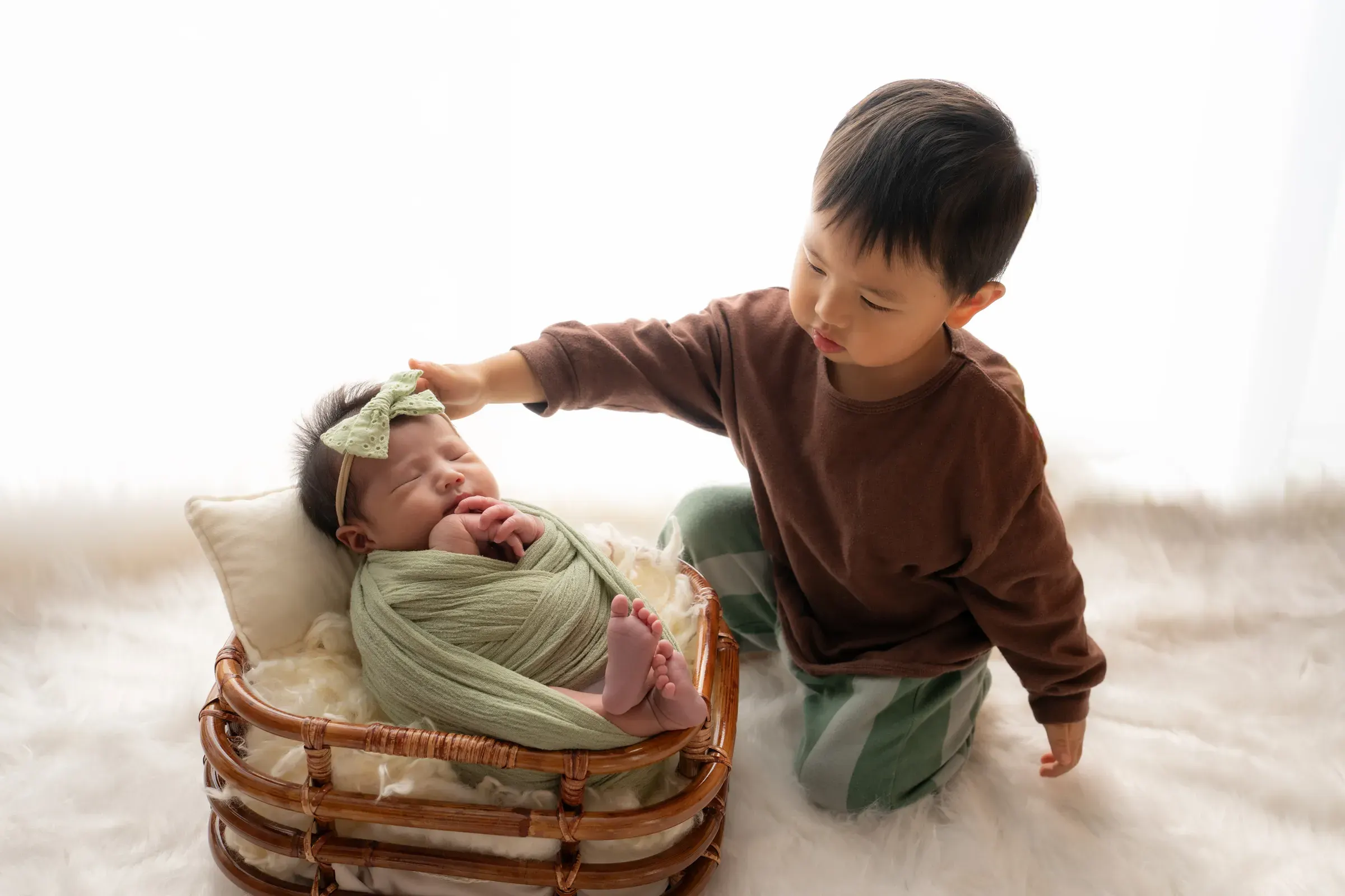 籠の中で眠る妹の頭をなでるお兄ちゃん